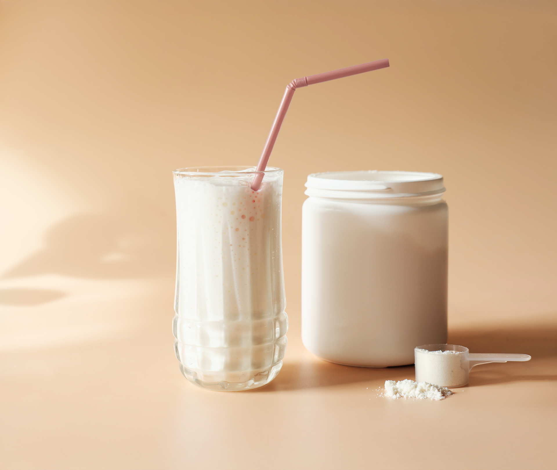 Protein Shake zum Frühstück oder als Frühstückersatz? Proteinshake im Glas mit Strohhalm und mit der Dose daneben